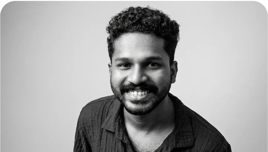 Black-and-white portrait of Ajesh Raj, smiling