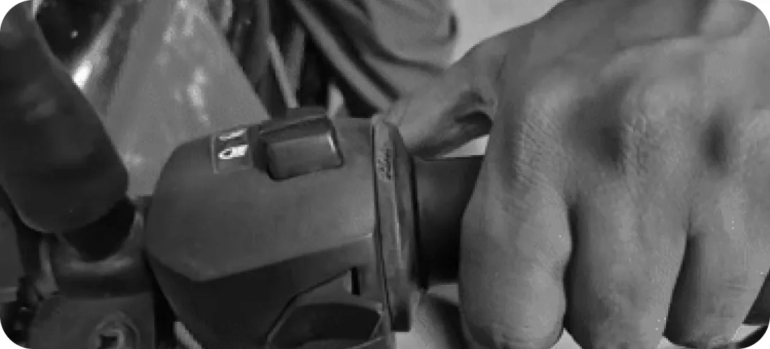 A thumb pressing a switch while the fingers hold the grip